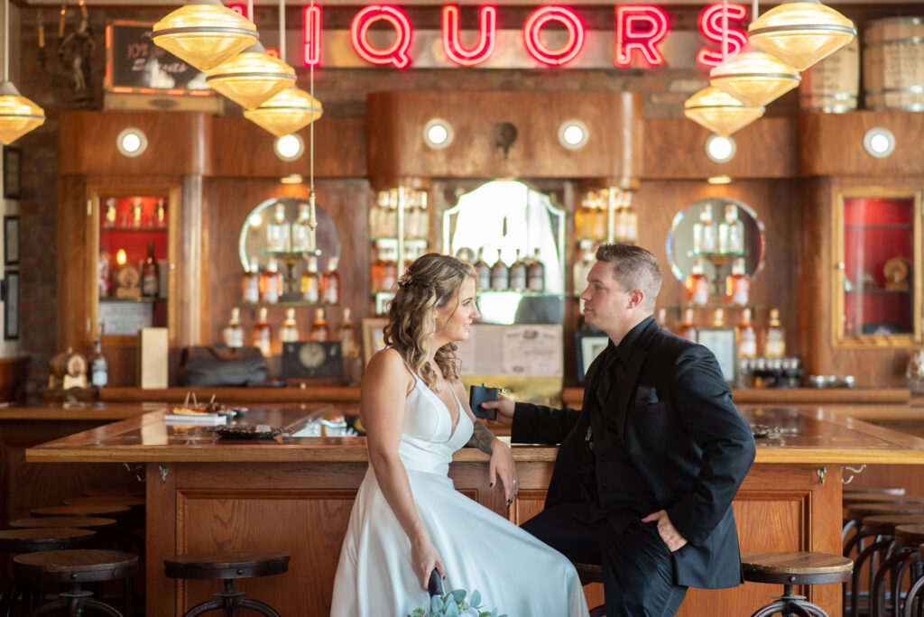 a bride and groom sitting at a bar