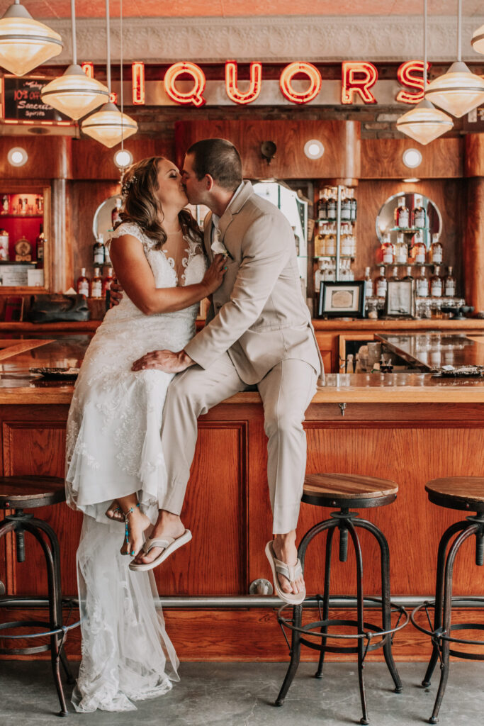 a bride and groom kissing in a bar