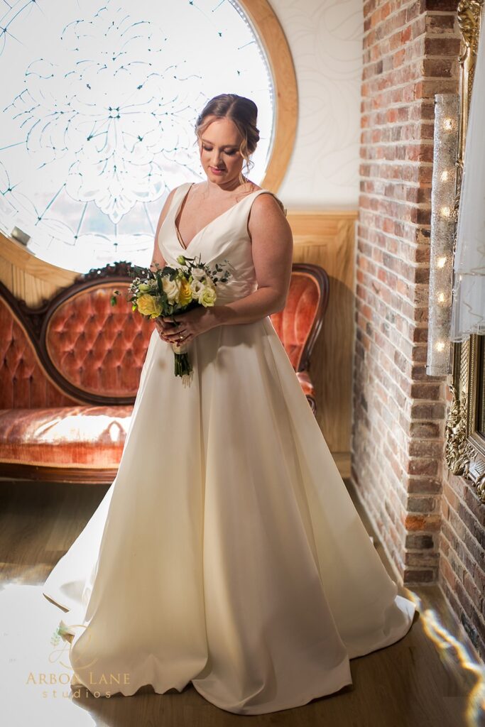 a woman in a wedding dress standing in front of a window