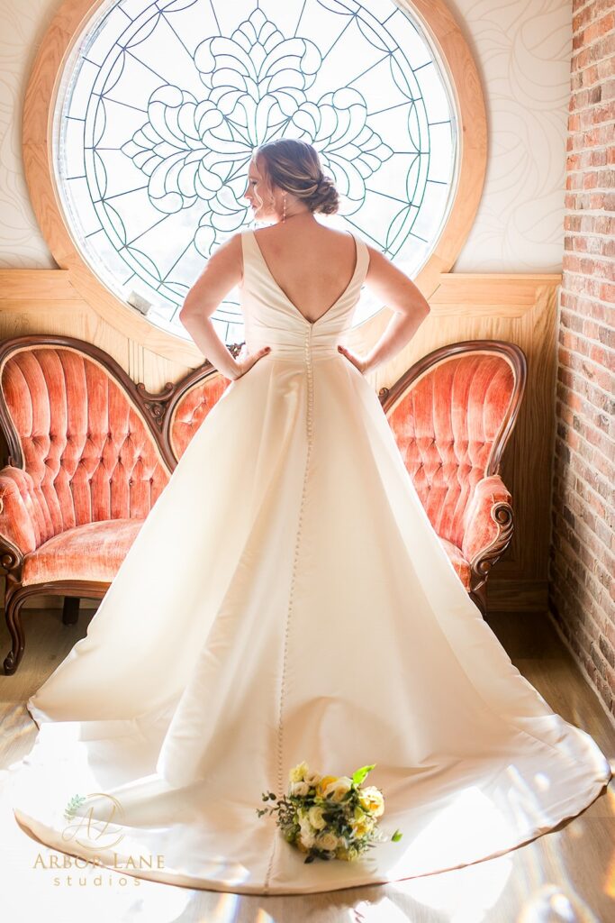 a woman in a wedding dress standing in front of a window