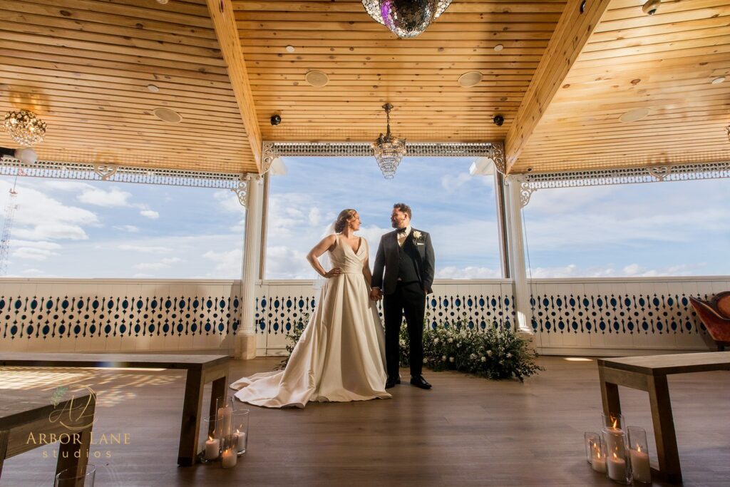 a bride and groom standing in a gazebo