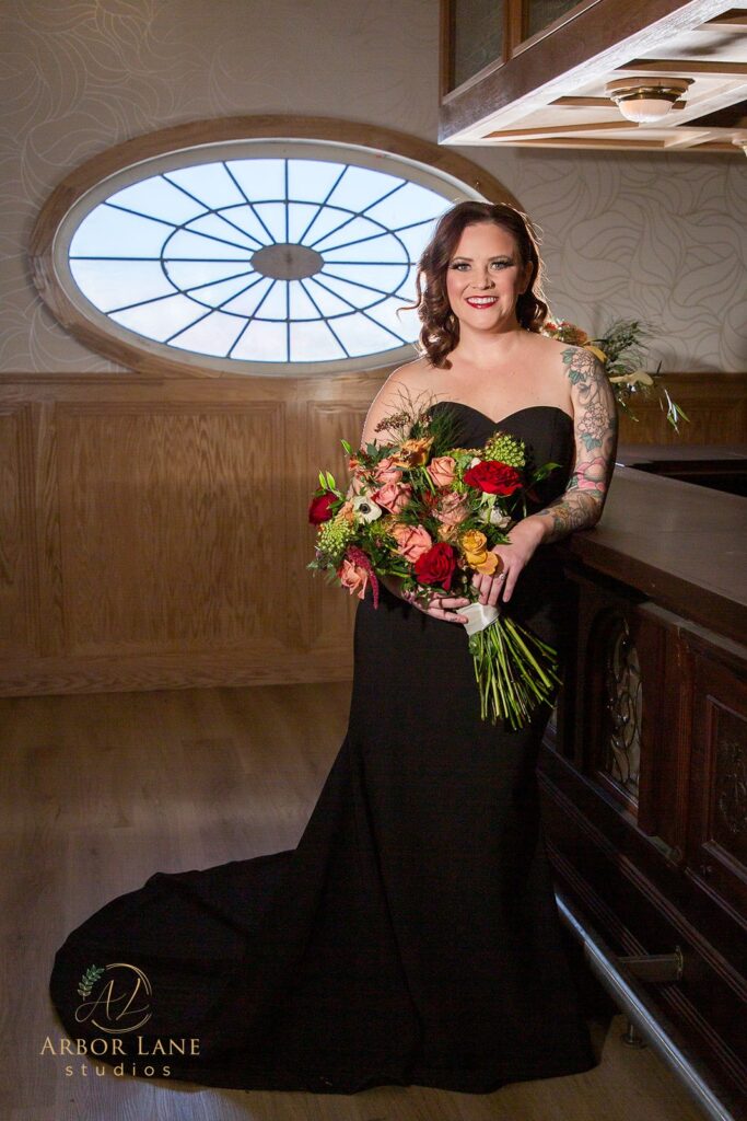 a woman in a black dress holding a bouquet of flowers