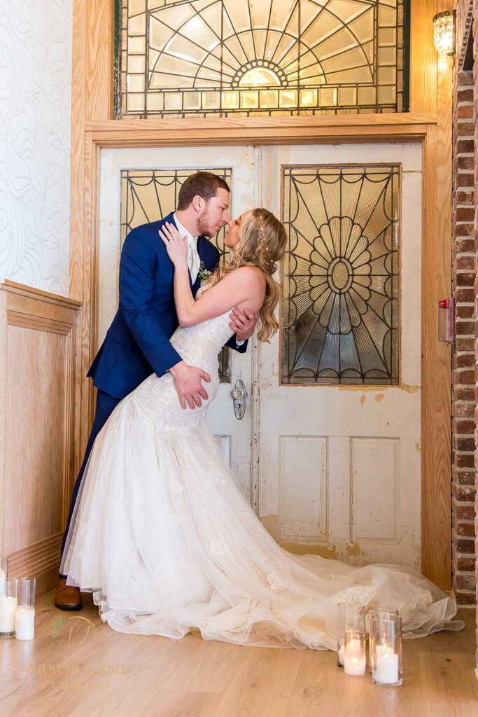 a bride and groom kissing in front of a door