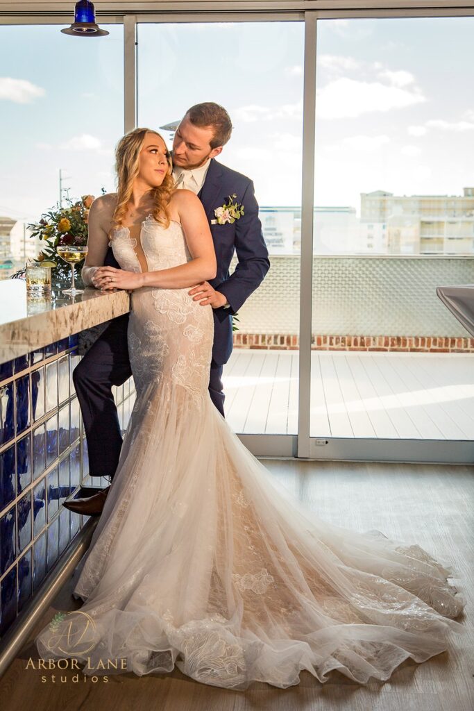 a bride and groom kissing on a balcony