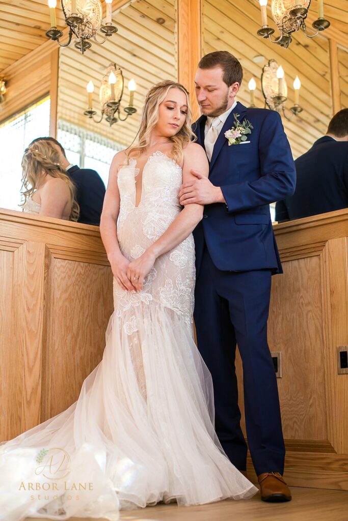 a bride and groom standing in front of a church pew