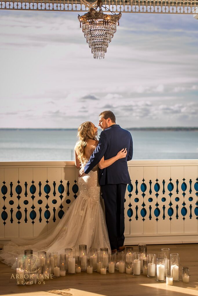 a bride and groom standing under a chandelier