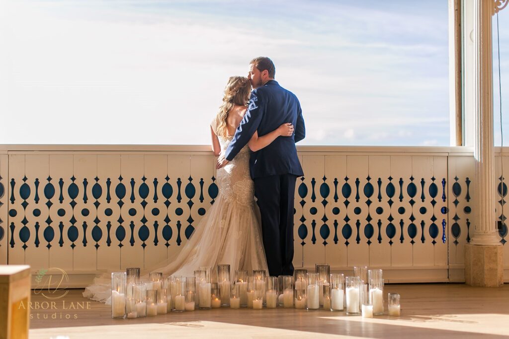 a bride and groom kissing on a balcony