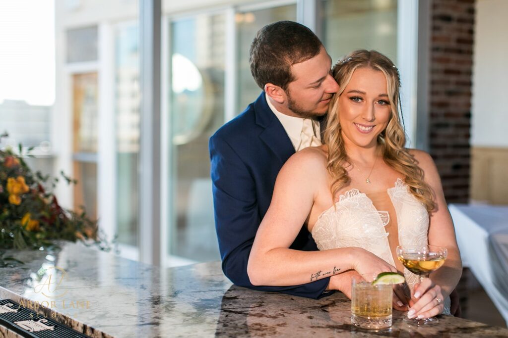 a bride and groom sitting at a bar