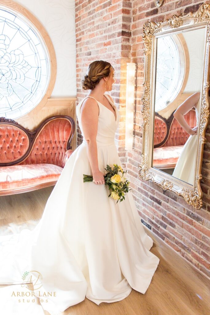 a woman in a wedding dress standing in front of a mirror