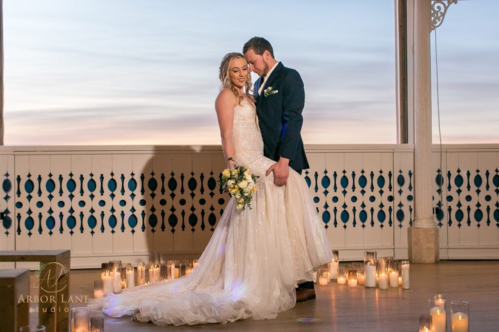 a bride and groom standing in front of candles