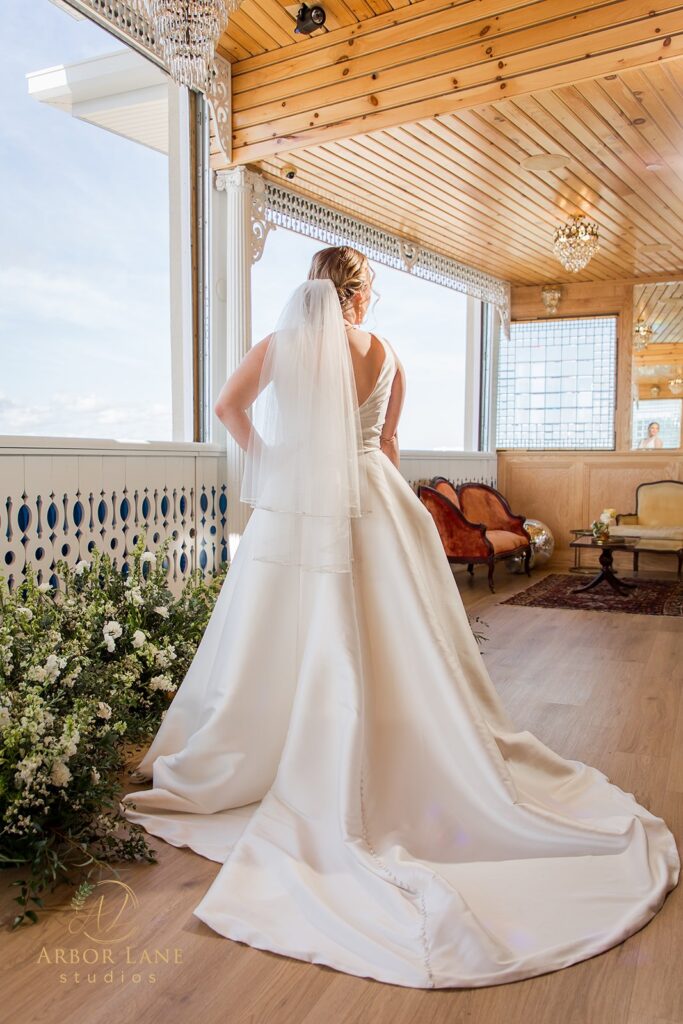 a woman in a wedding dress looking out a window