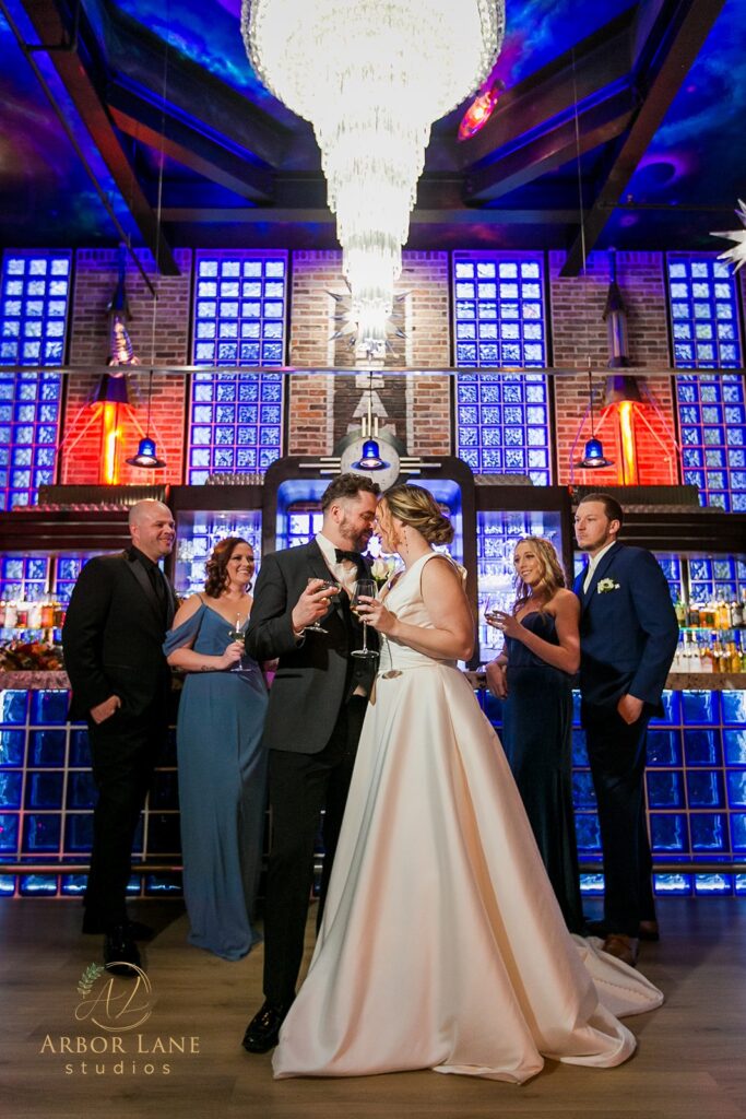 a bride and groom standing in front of a chandelier