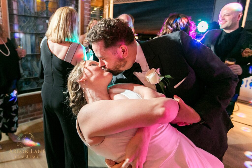 a man and woman kissing on a dance floor