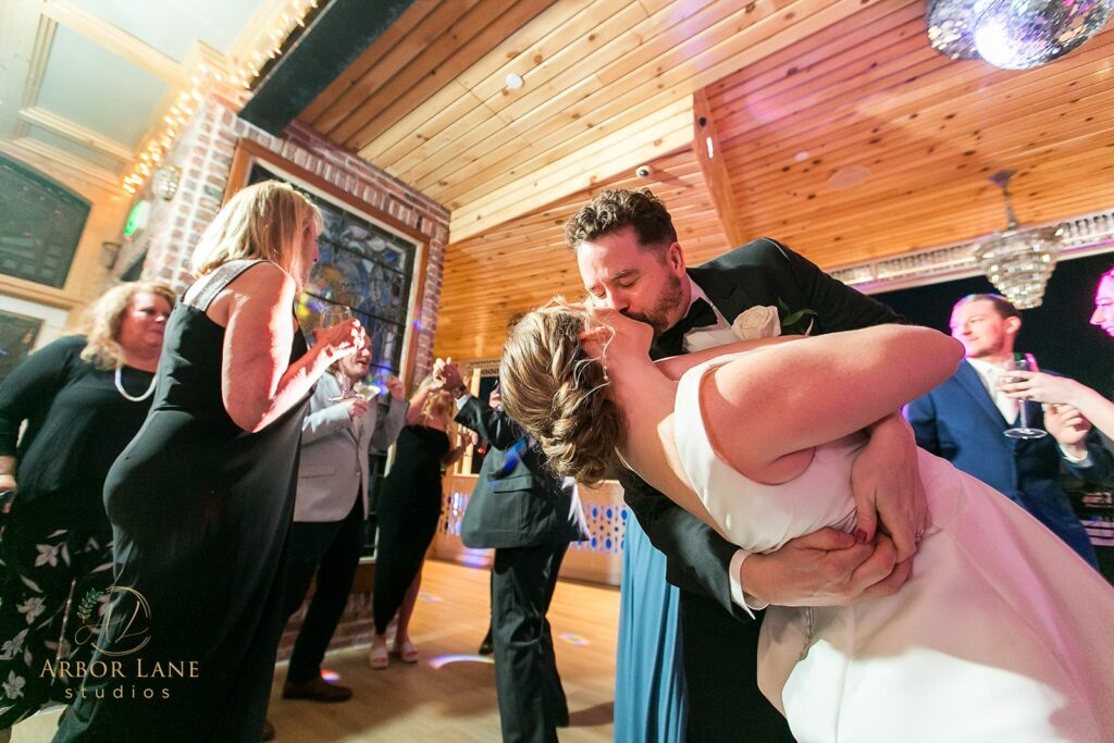 a bride and groom kissing on the dance floor