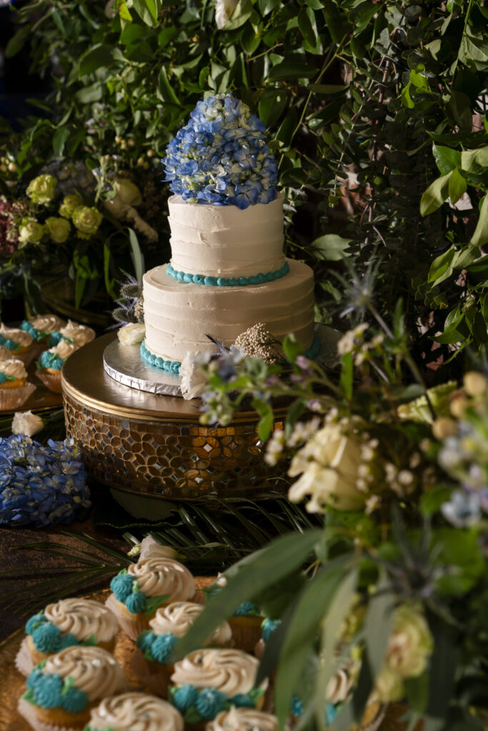 a wedding cake and cupcakes on a table