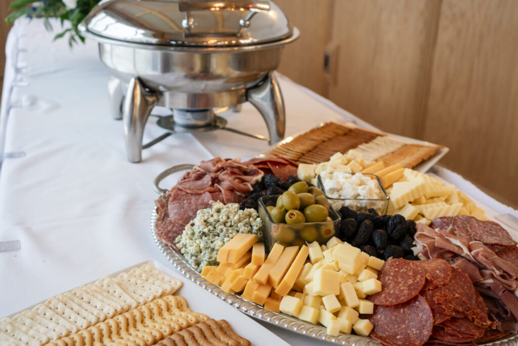 a platter of cheeses, crackers, and meats on a table