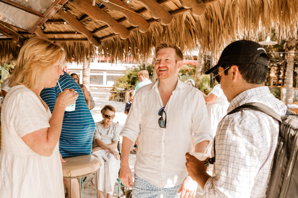 a group of people standing under a thatched roof