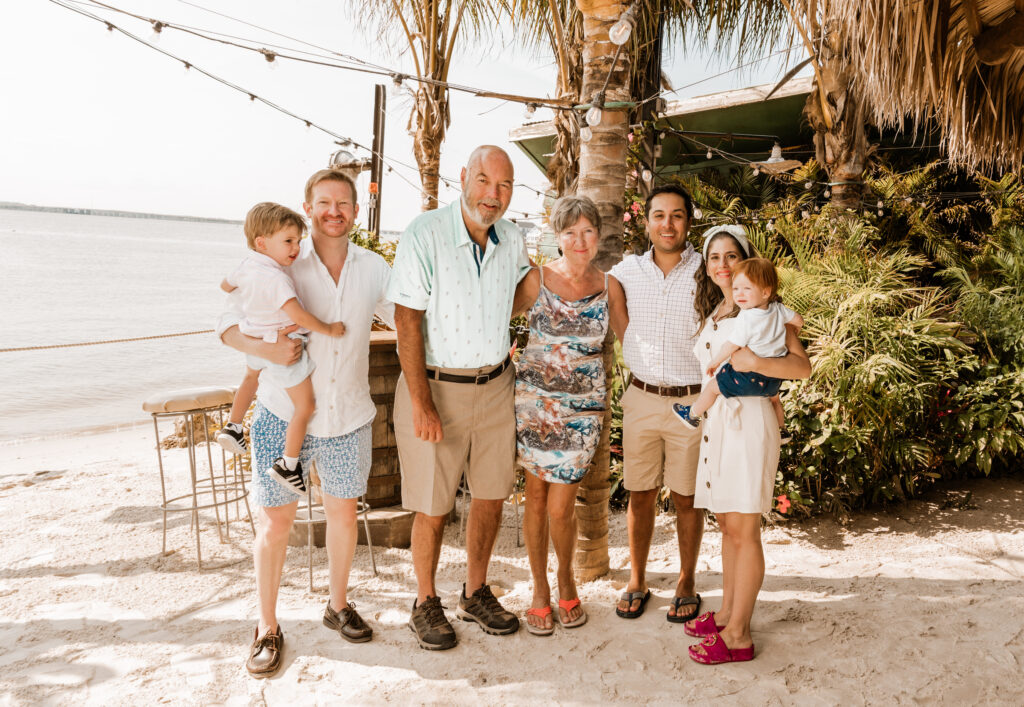 a group of people standing on top of a sandy beach