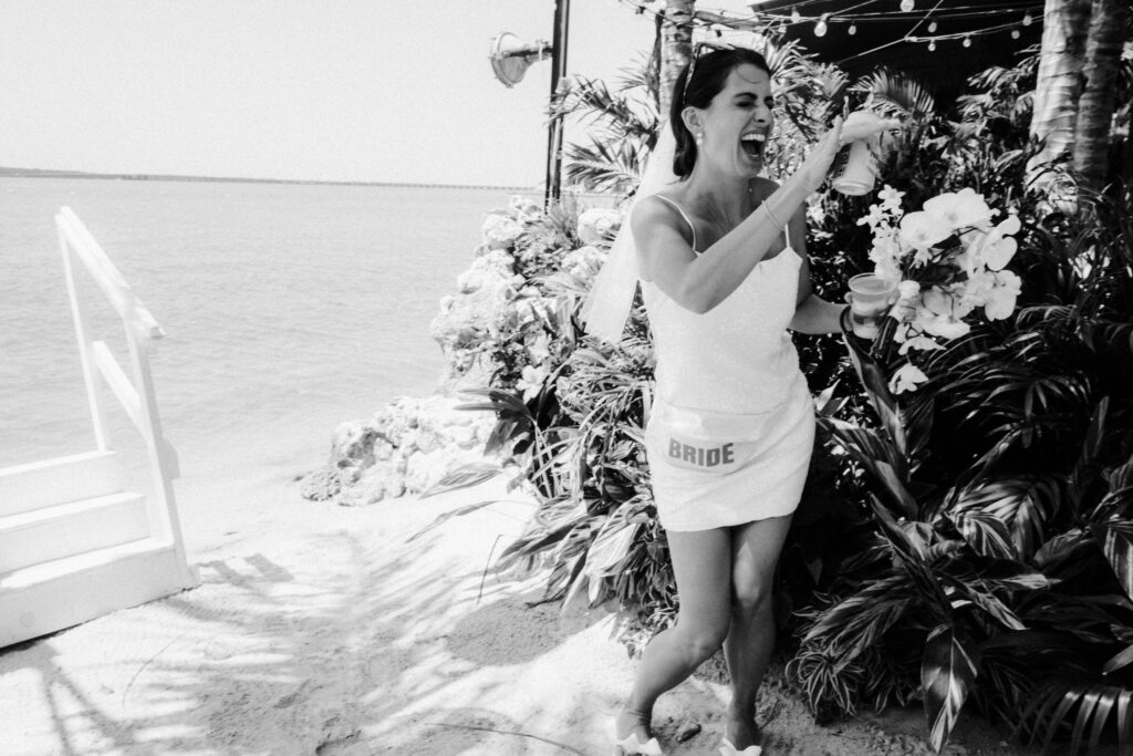 a woman standing on a beach next to a bunch of flowers