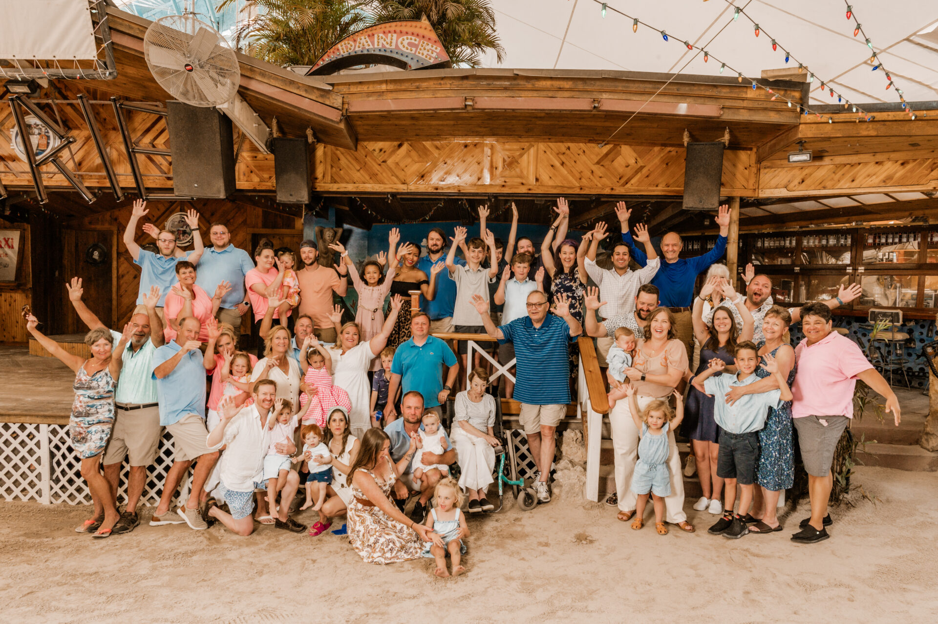 a group of people standing on top of a sandy beach