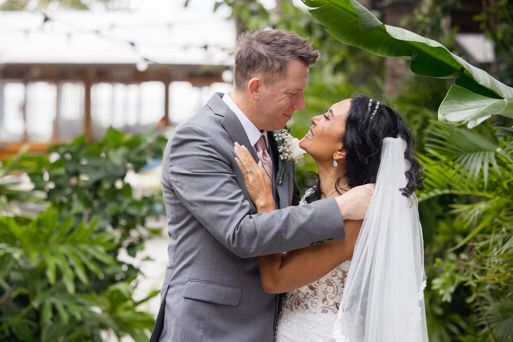 a bride and groom standing in front of a lush green garden