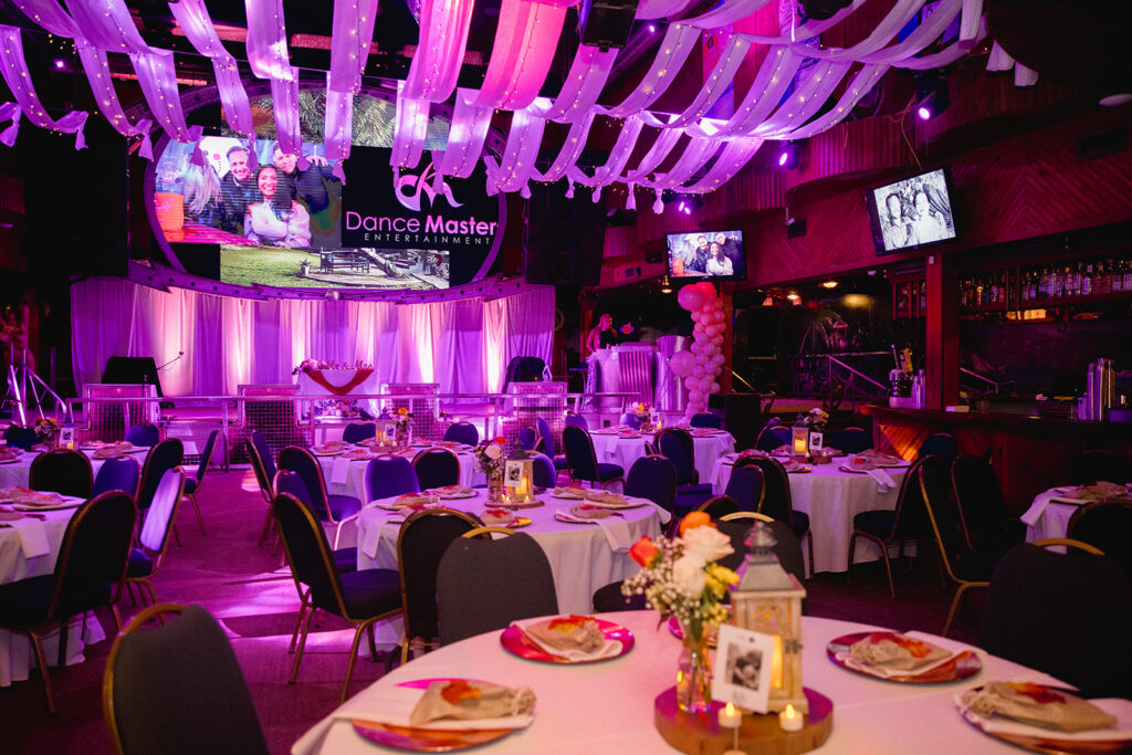 a banquet hall with tables, chairs, and televisions