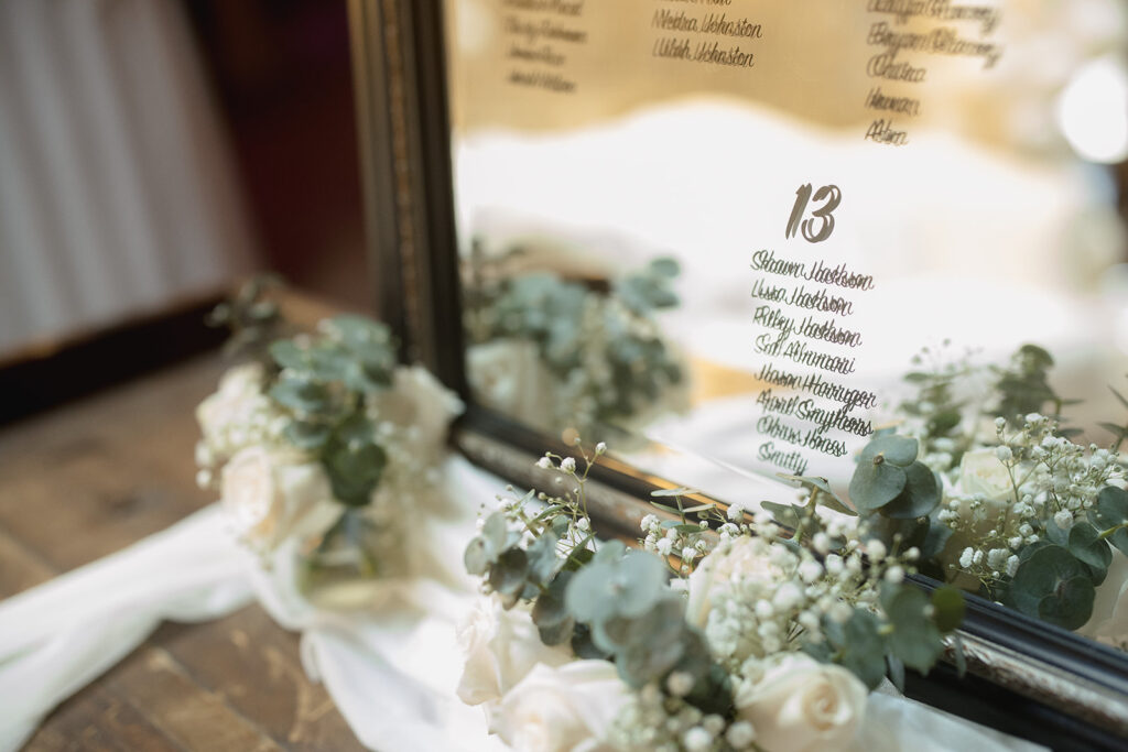 a table with a mirror and flowers on it