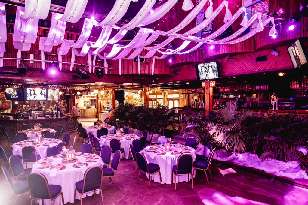 a restaurant with purple lighting and tables and chairs