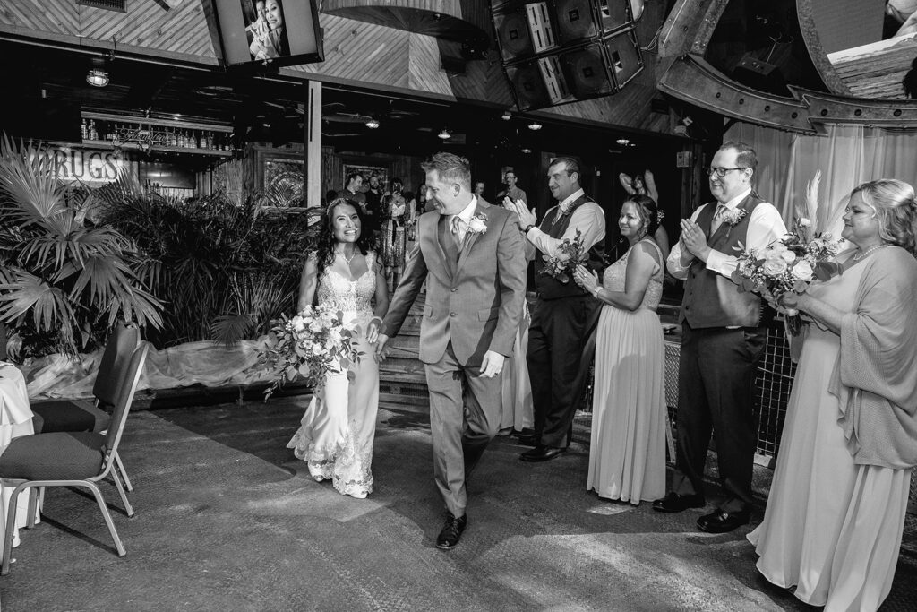 a black and white photo of a bride and groom walking down the aisle