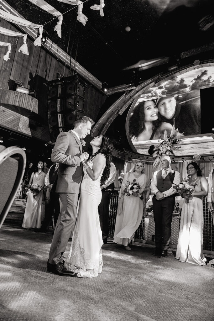 a black and white photo of a bride and groom dancing