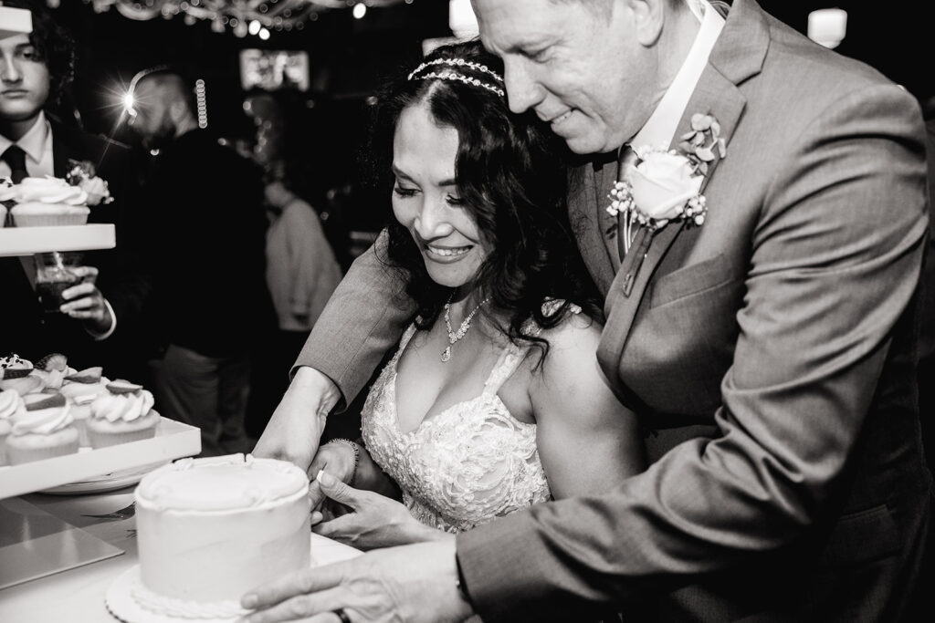 a man and woman cutting a cake together